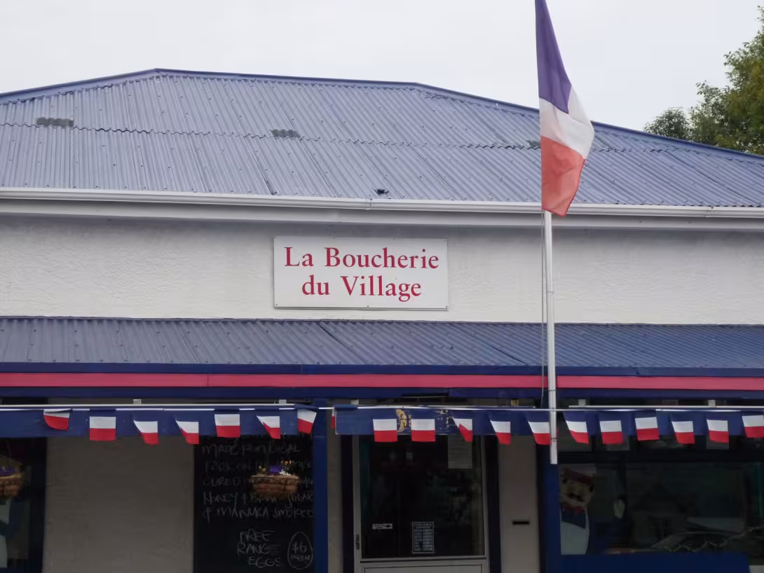 A butcher’s shop flying the French flag in New Zealand: you could only be in the village of Akaroa, where residents are proud… of being French (or almost!)